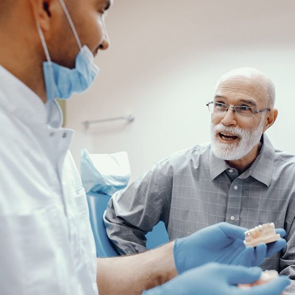 senior man asking his denture dentist in Grand Prairie questions about dentures 