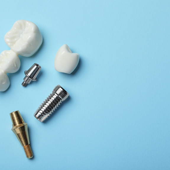 Bird’s eye view of dental bridge and implants on light blue background