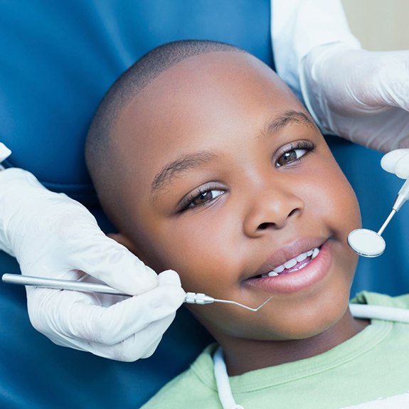 smiling young boy in the dentist’s treatment chair 