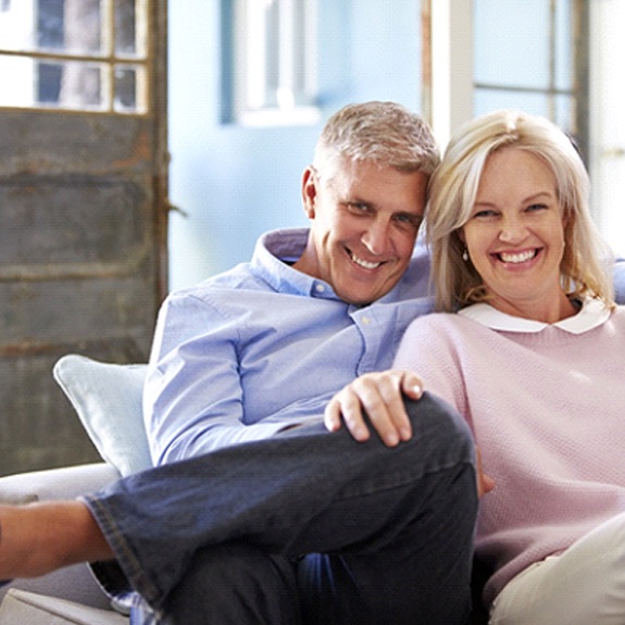 happy senior couple sitting on their couch