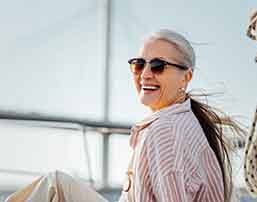 Woman with sunglasses smiling on boat