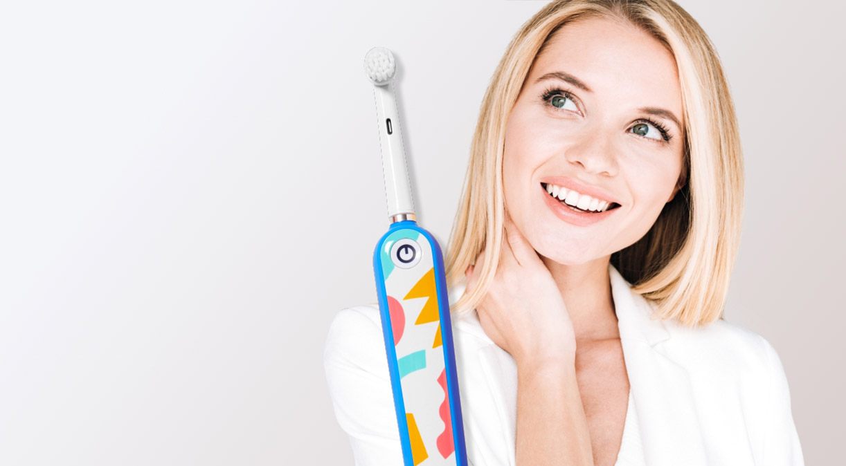 Woman with healthy smile and electric toothbrush