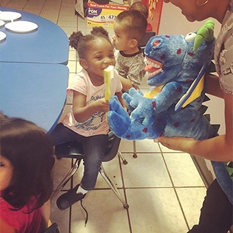 Dentist showing kids how to brush teeth