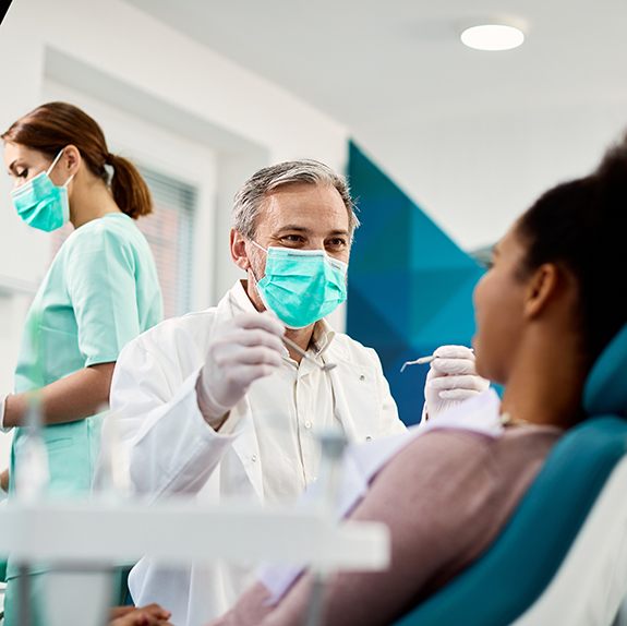 Smiling dentist conducting exam