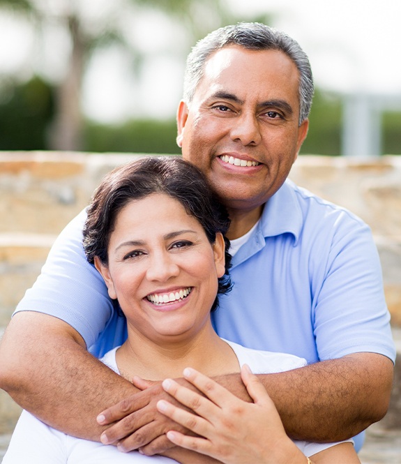 Older man and woman smiling after root canal therapy