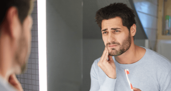 Man in need of emergency dentistry holding jaw