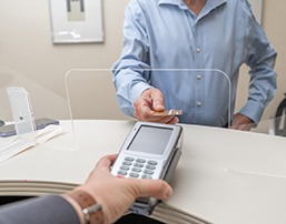 A man paying the cost of veneers