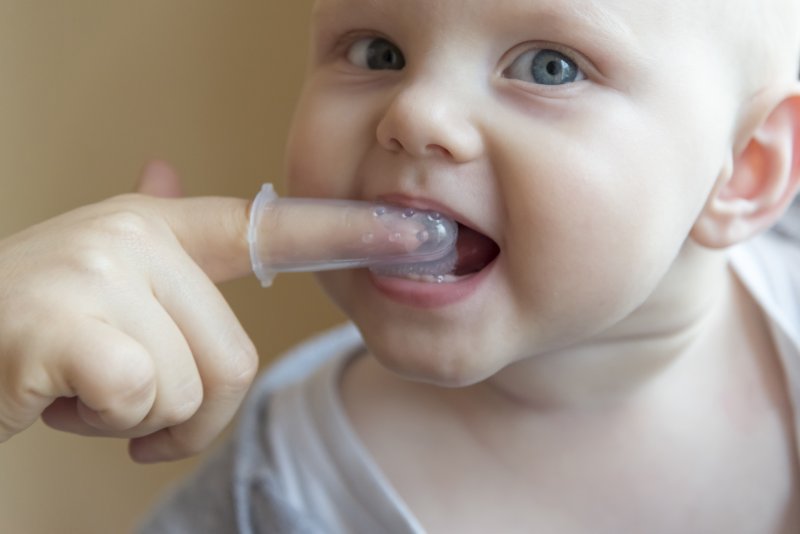 Parent brushing baby's teeth