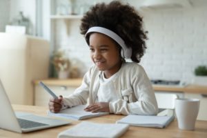 Little girl smiling during virtual learning after visiting children's dentist