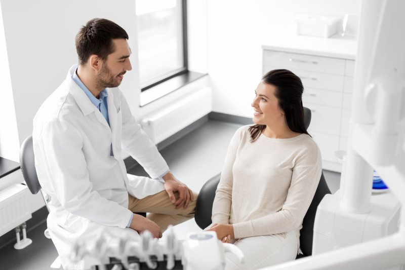 dentist talking to patient about rinsing after brushing 