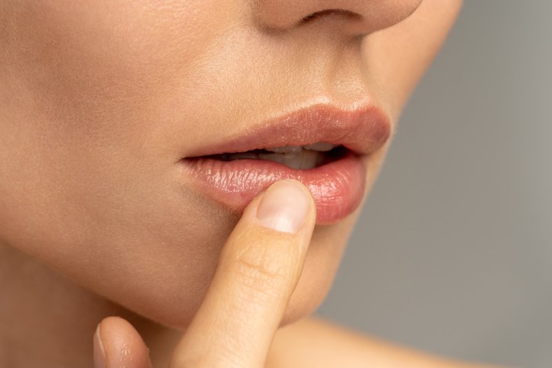 closeup of woman moisturizing her lips 